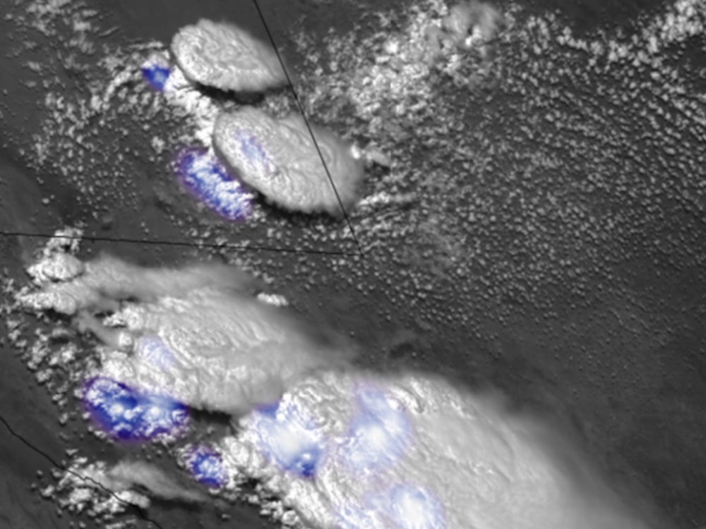 Clouds at various stages of development are seen in white in this visible imagery, with lightning indicated by the blue shading.