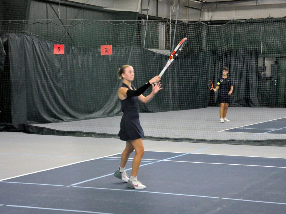 Penn State Altoona student-athlete Lexi Colaianni playing tennis in an indoor facility.