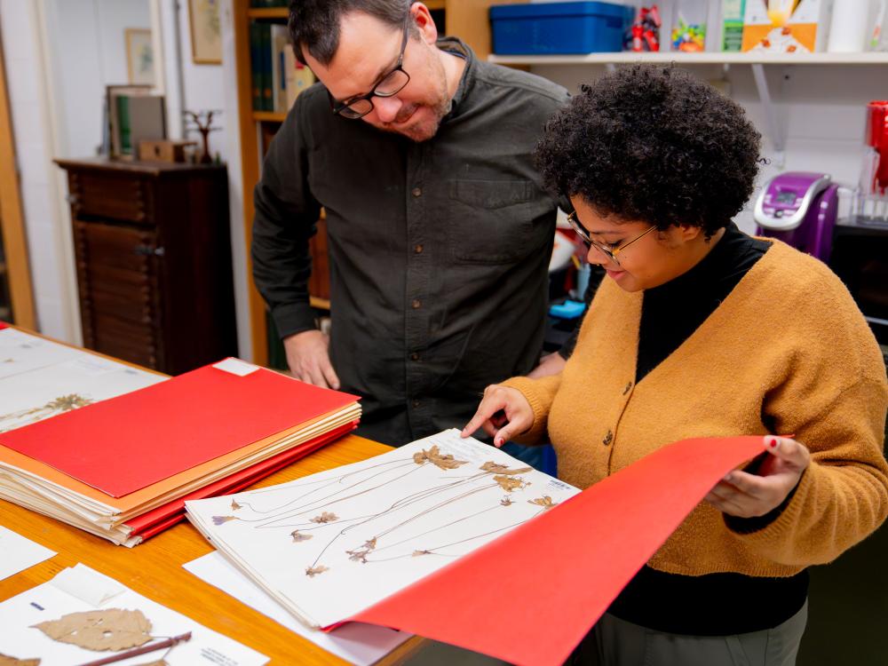 Two people look at a book