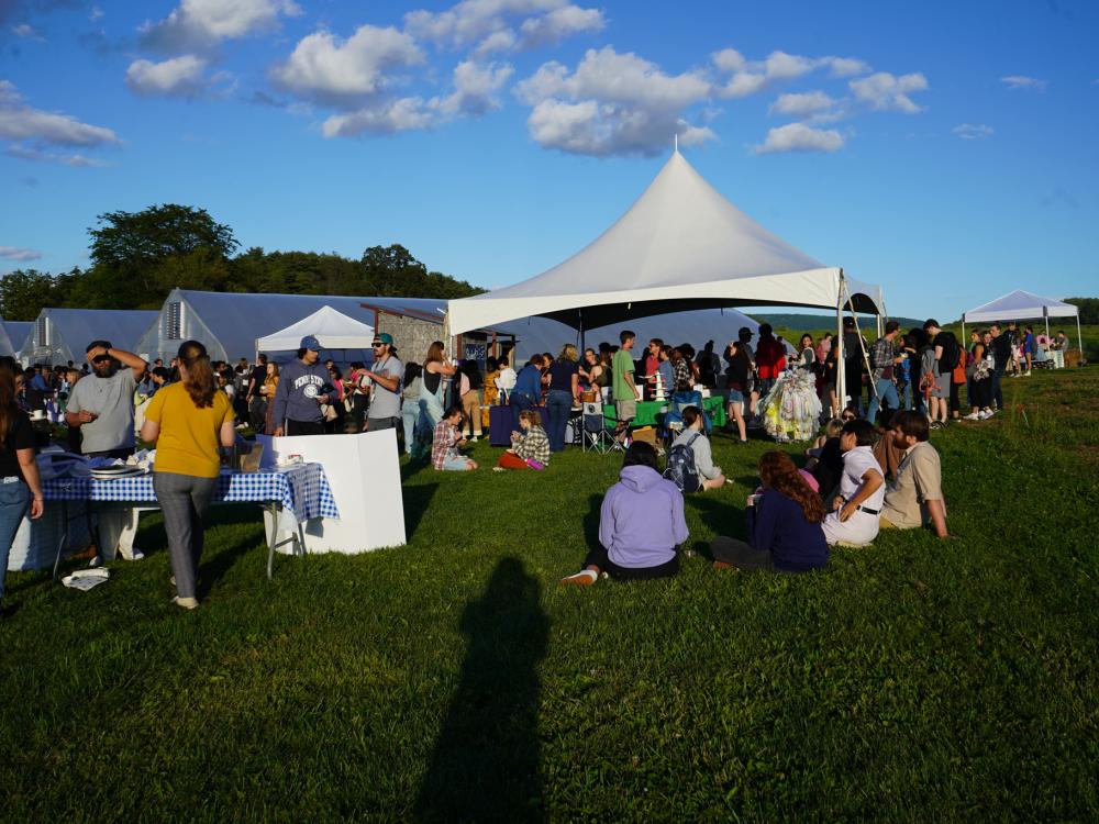 Guests gather in the grass and around displays at the Student Farm Harvest Fest