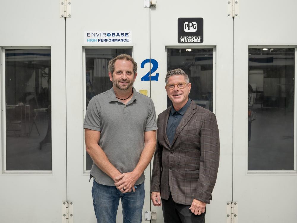 Shaun D. Hack, instructor and co-department head of collision repair at Pennsylvania College of Technology, and Todd Warren, territory manager for PPG Industries, stand in Penn College's collision repair lab