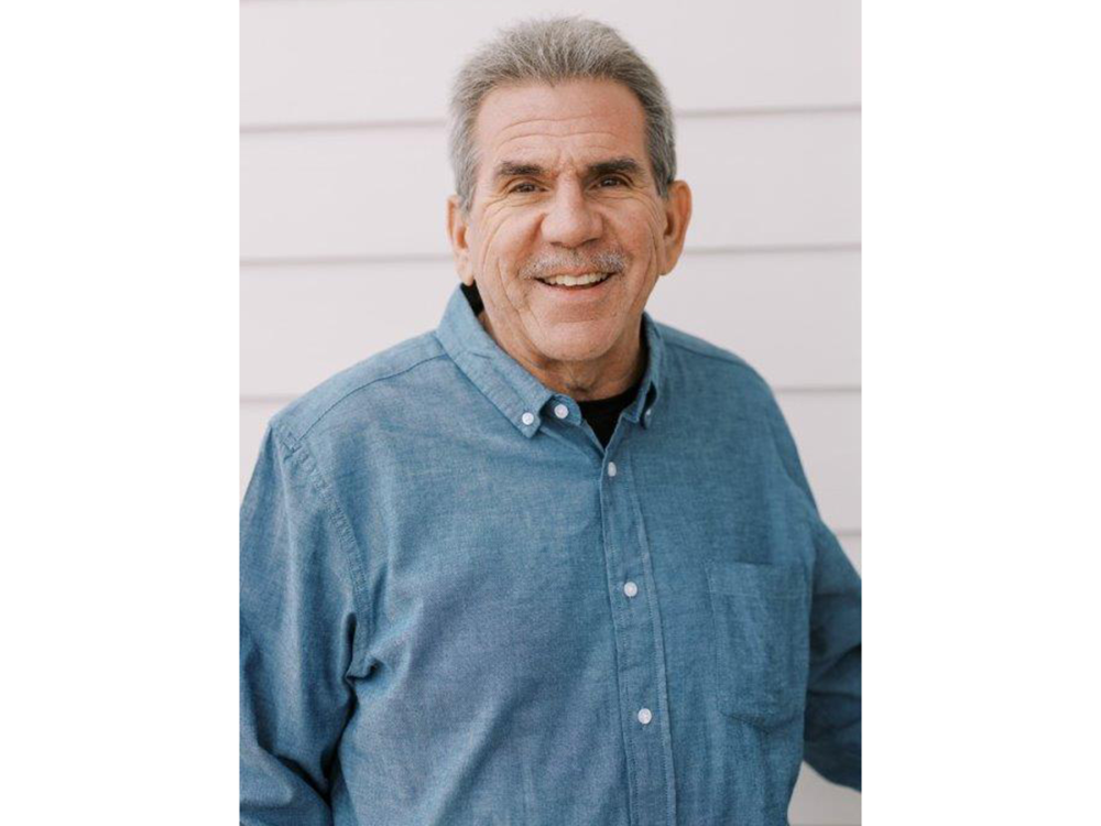 Portrait of a person in a blue shirt against a white background