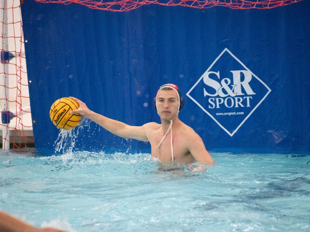 A goalkeeper for the Penn State Behrend men's water polo team prepares to throw the ball.