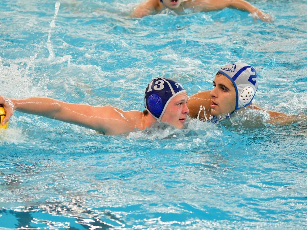 Two water polo players face each other in the pool.