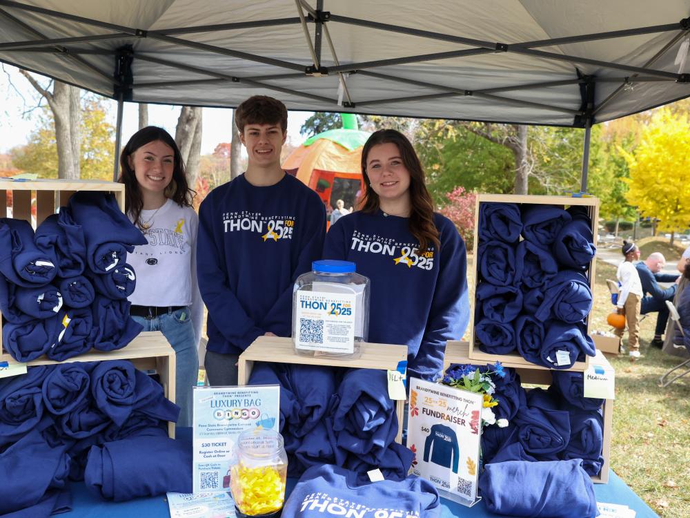 students selling THON sweatshirts