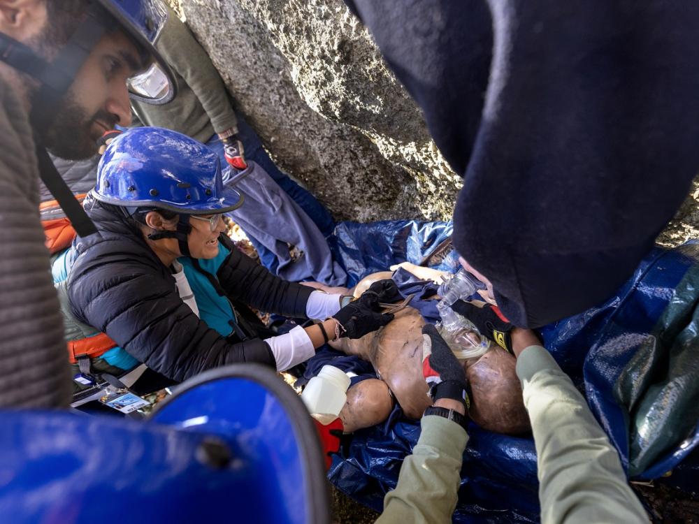 Students participate in a simulated rope rescue training exercise, providing care to an mannequin simulating an injured rock climber