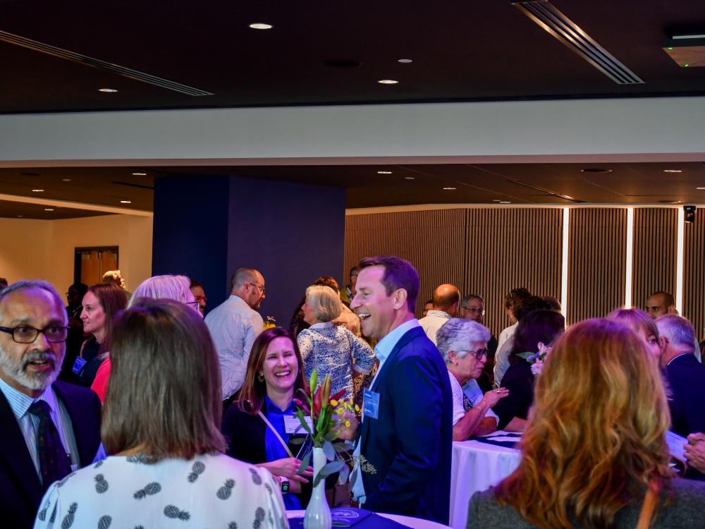Faculty mingle around cocktail tables