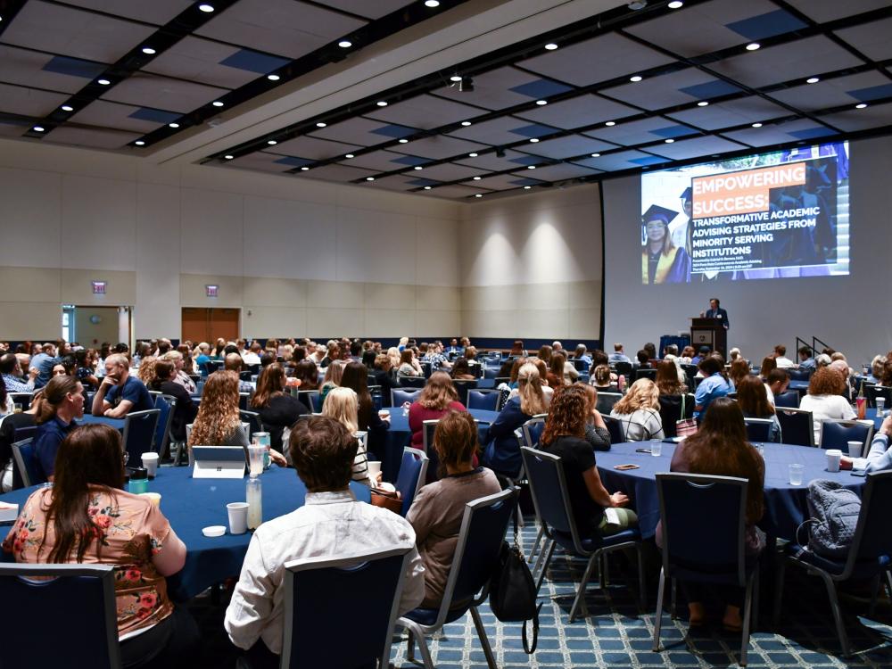 Photo of seated crowd attending an academic advising conference 