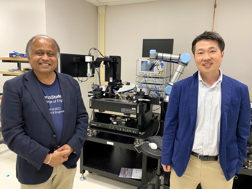 Two people standing with engineering lab equipment.
