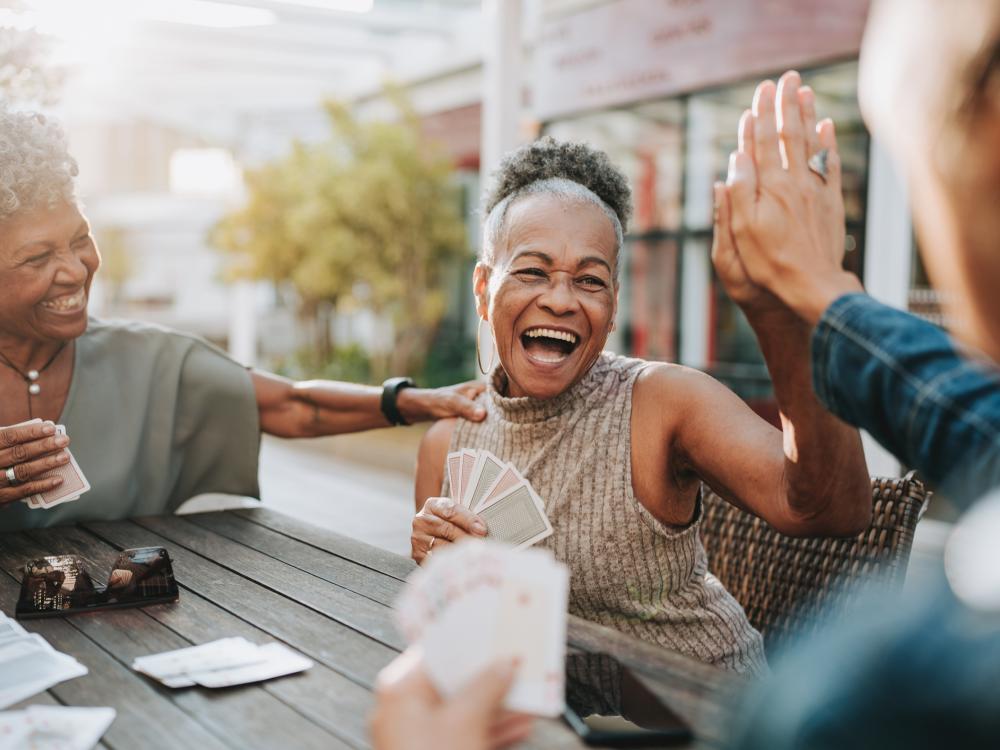 older people playing cards outside