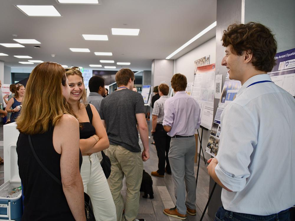 People talking in front of research posters