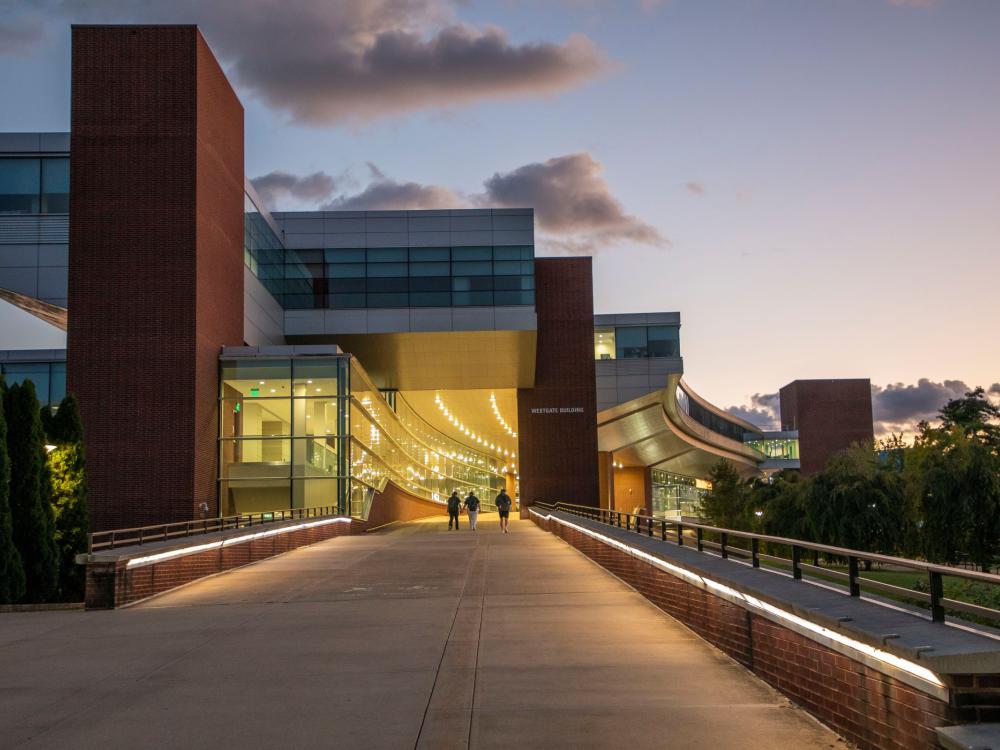 brick and glass campus building at dusk