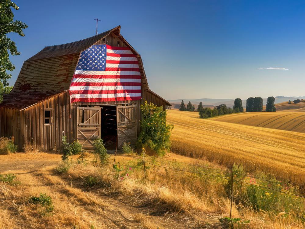 Barn with flag painted on it and rolling fields nearby