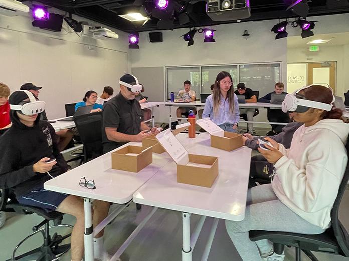 A group of students wearing virtual reality headsets in a classroom