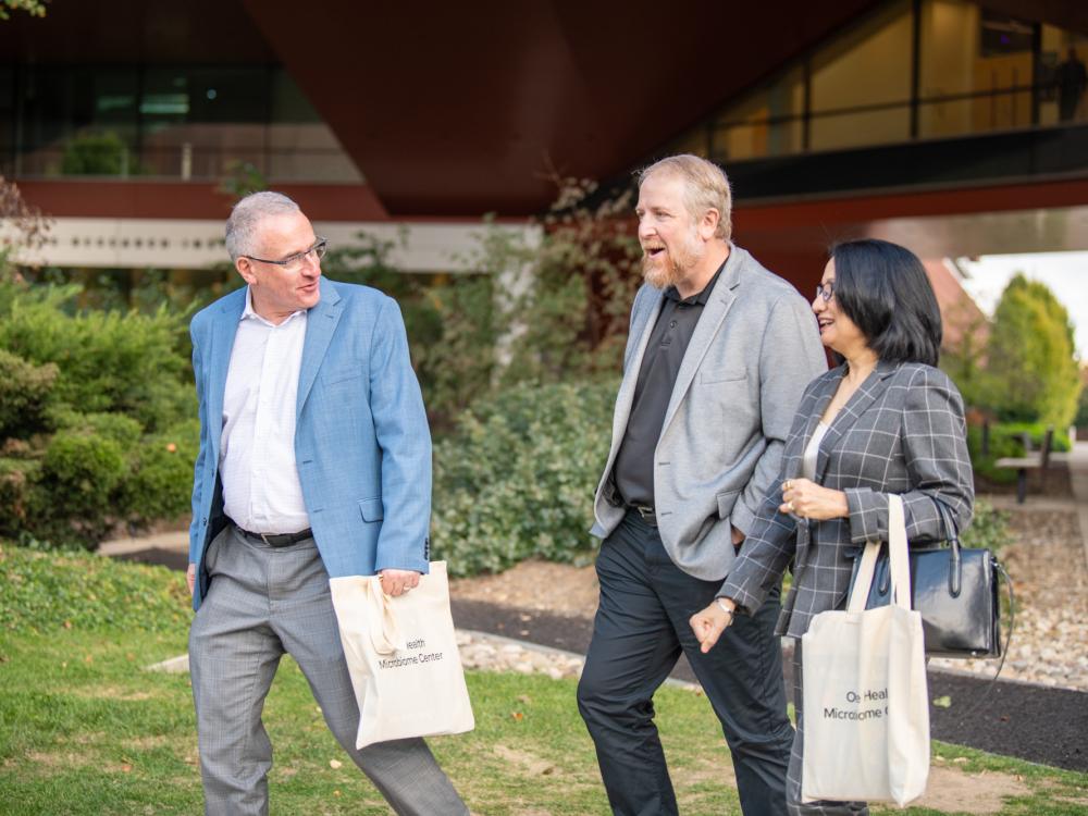 Andrew Read, Seth Bordenstein and Neeli Bendapudi walk outside with a building in the background.