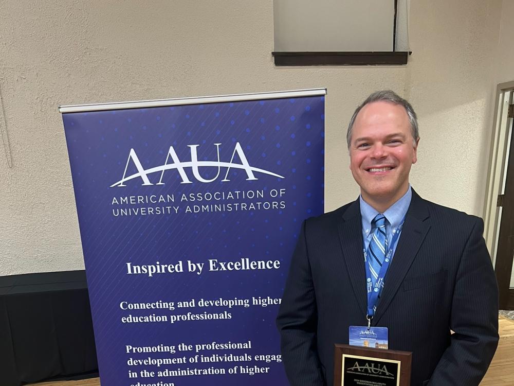 Michael J. Pennington holding an award