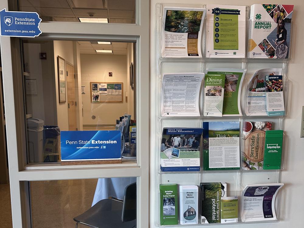 A photo of the Extension offices including a wall holder with various pamphlets and a sign that says Penn State Extension.