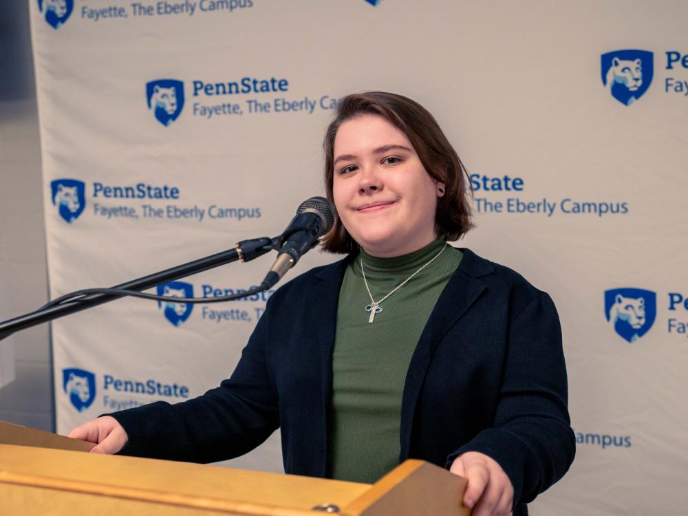 Skylar Wilson, a third-year psychology student at Penn State Fayette, The Eberly Campus, standing at the podium of the 15th annual Scholarship Donor Dinner. 