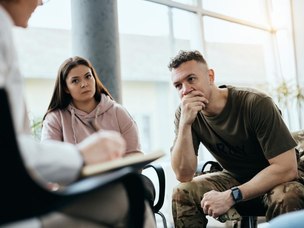 Military couple sitting with therapist