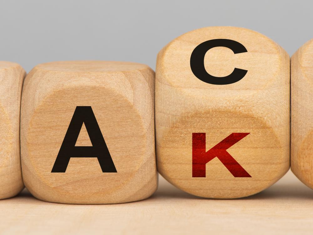 The words "fake" and "fact" printed on wooden cubes