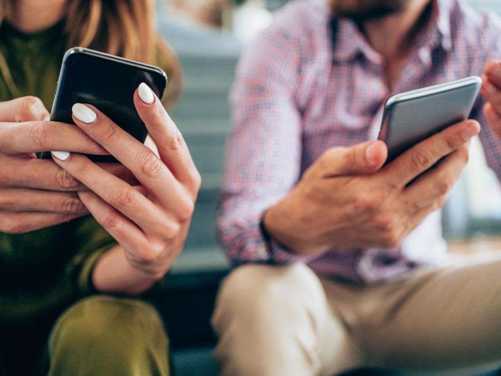 Two people holding smart phones