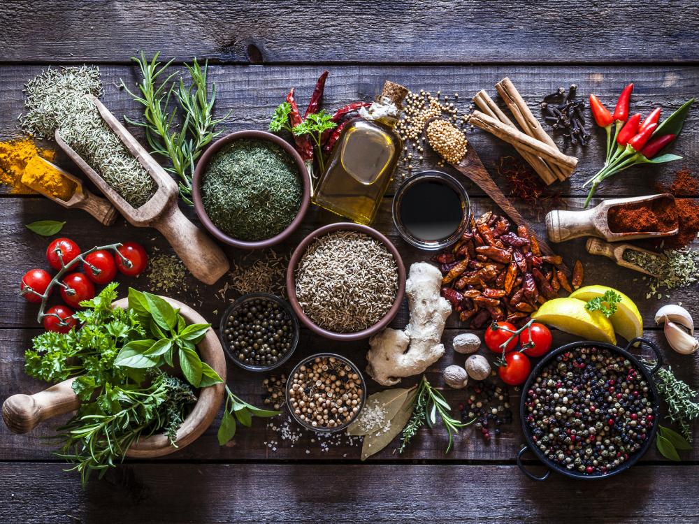 an overhead view of whole and ground herbs and spices, fresh and dried