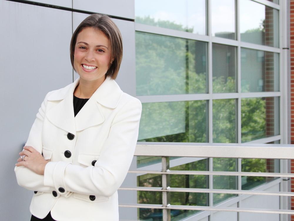 A photo of Jennifer Eury smiling and standing with her arms crossed.