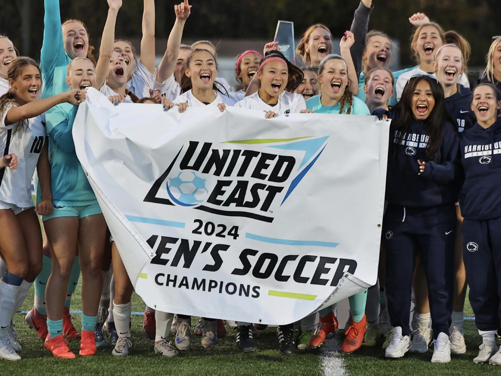 Penn State Harrisburg women's soccer team holding a banner that says United East 2024 Women's Soccer Champions