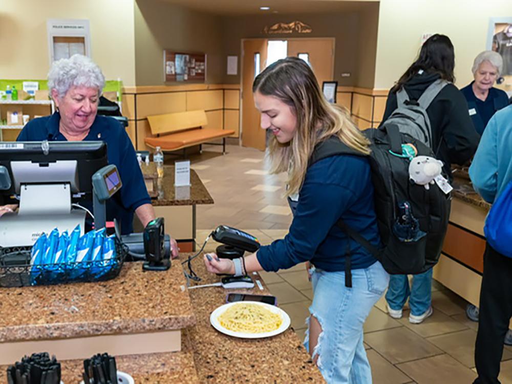 A Penn State student uses her mobile id+ card on her watch to pay in a Penn State dining common. 