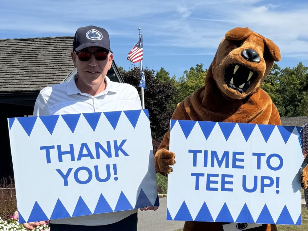 David Horton and the Nittany Lion hold up thank you signs at the 26th annual Penn State IT Golf Tournament.