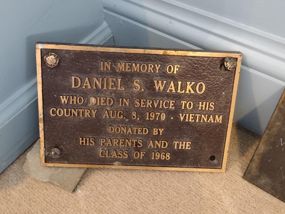 A plaque in memory of fallen servicemember Daniel S. Walko rests on the ground.