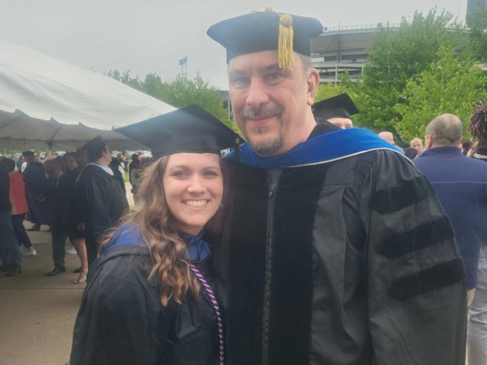 A woman and a man in graduation robes. 