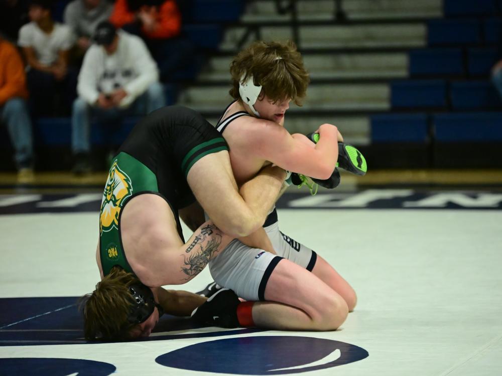 A Penn State Behrend wrestler gains leverage on an opponent, who is upended.