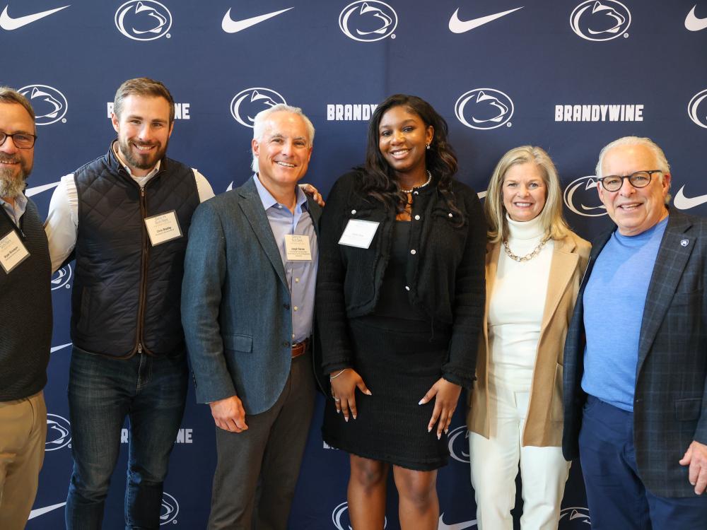 student with advisory board members pose for a photo