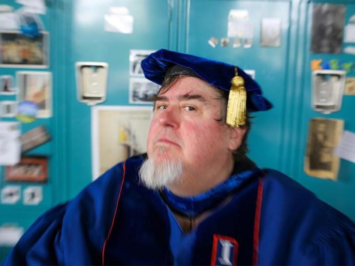 Selfie of a man wearing blue commencement regalia