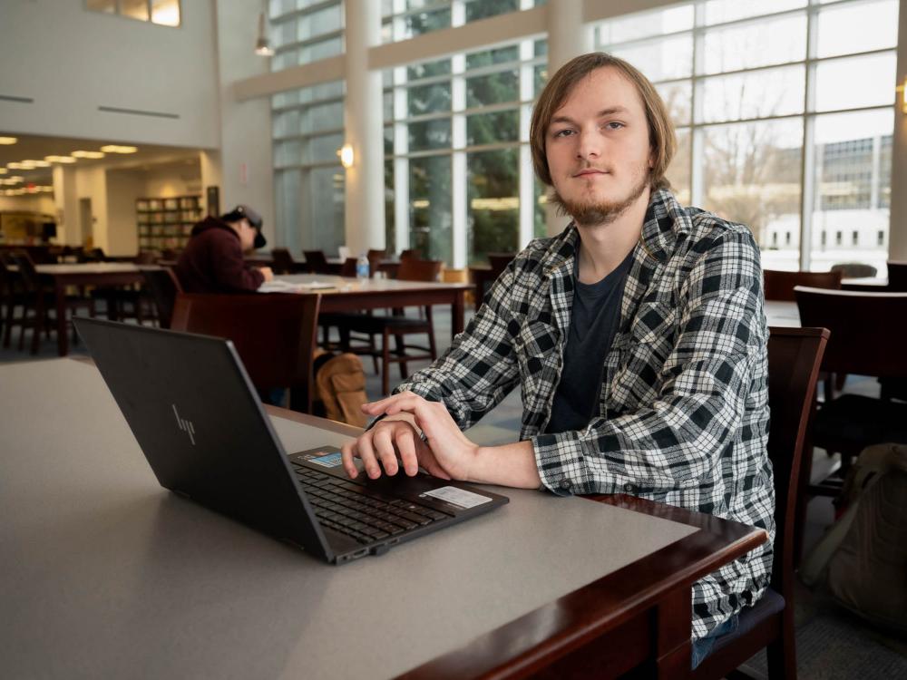 Dalton Nice sitting at a table with a laptop. 