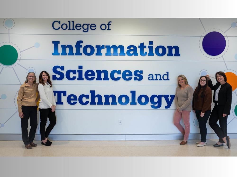 five people stand in front of colorful wall