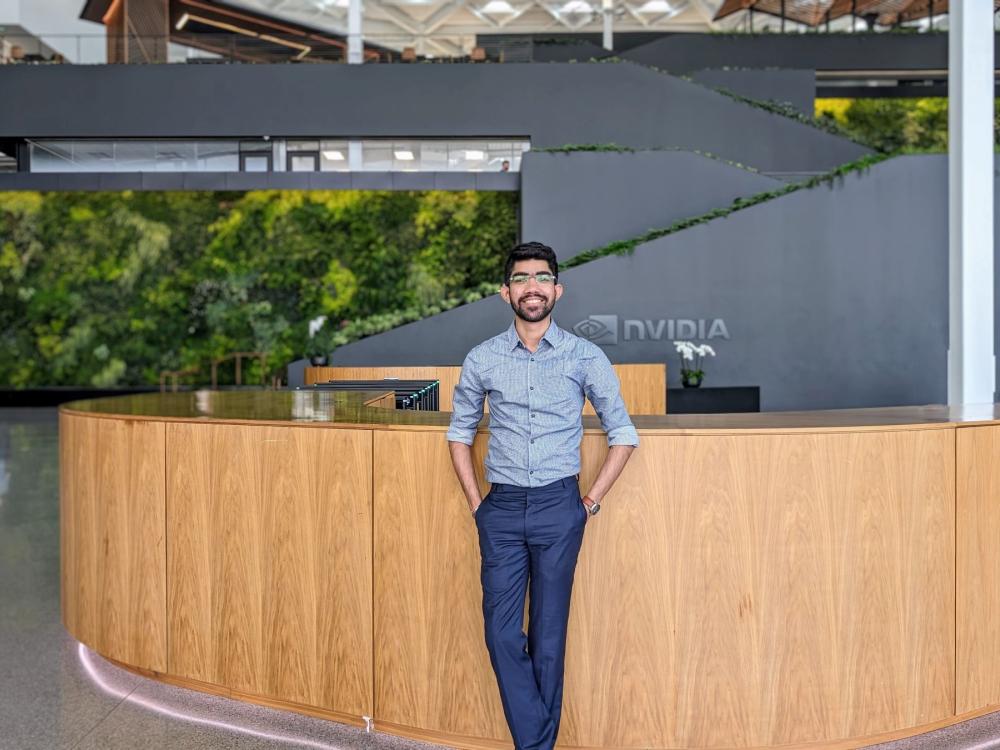 person with dark facial hair and glasses in office building