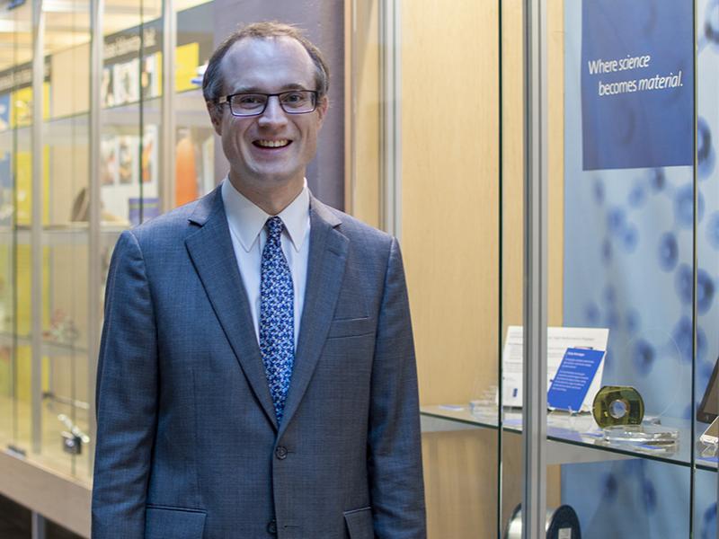 Glass expert John Mauro stands near a glass display