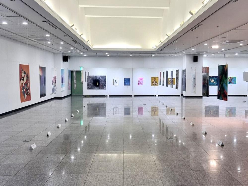 A white art gallery with colorful posters on the walls.