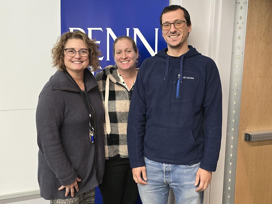 Three people standing and smiling at the camera.