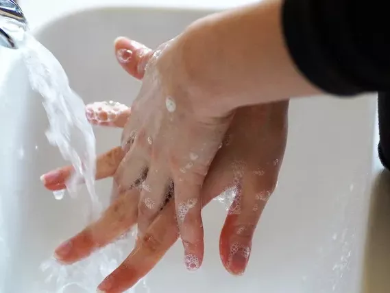 A person washing their hands at a sink