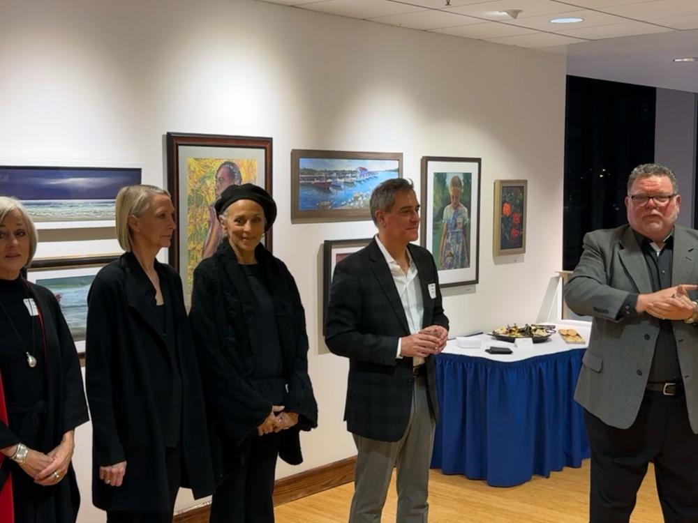 Community members and guest speakers gather in an art gallery for a cultural event