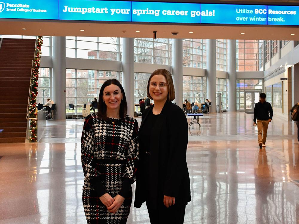 A photo of Ashley Rippey and Alexandra Stossel standing in the Business Building Atrium.