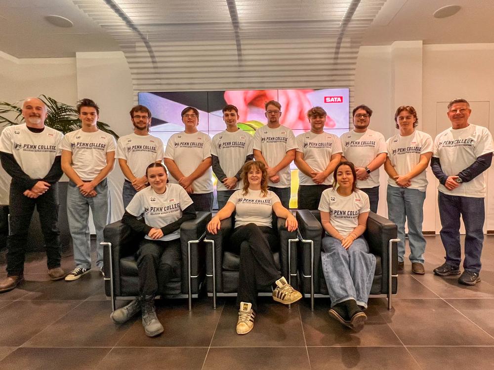 A large group of people pose for a photo in an indoor office space