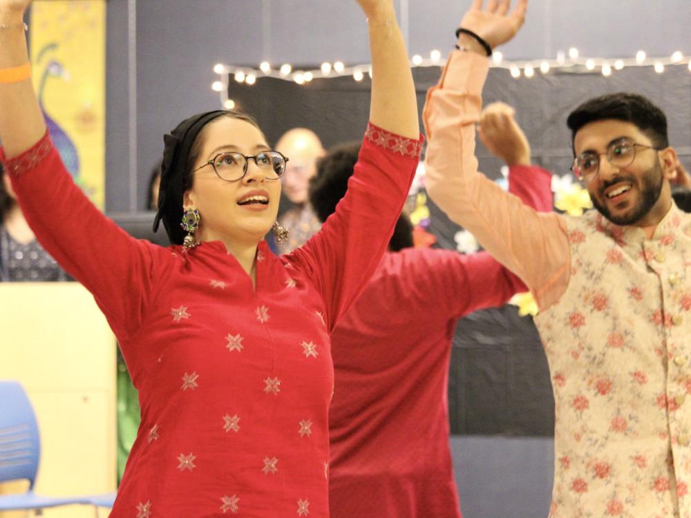 Two students dance at a Holi celebration