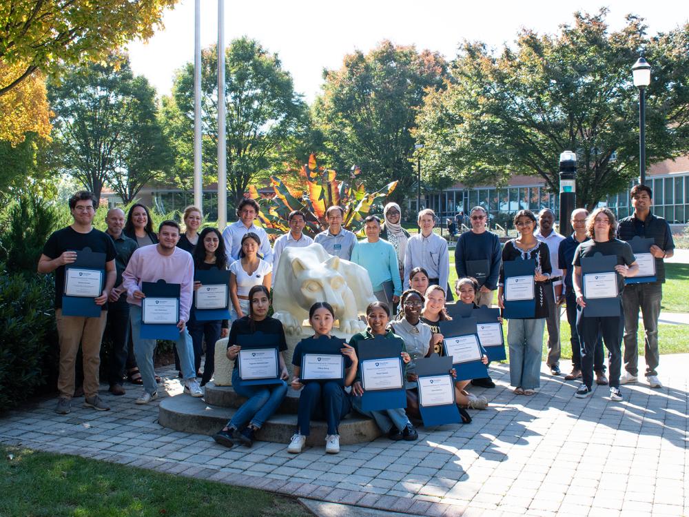 Group photo of REU award participants by the Nittany Lion statue