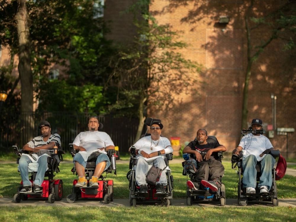 A group of people in wheelchairs outdoors