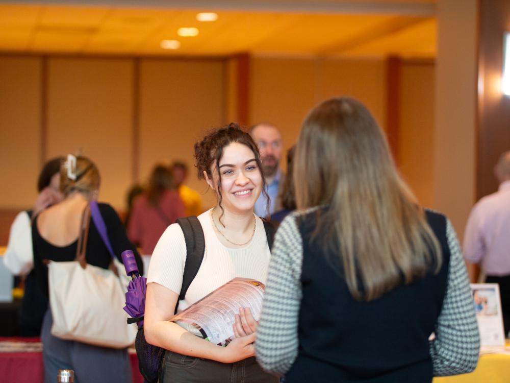 Girl smiling and talking to someone at the Health Professions Expo
