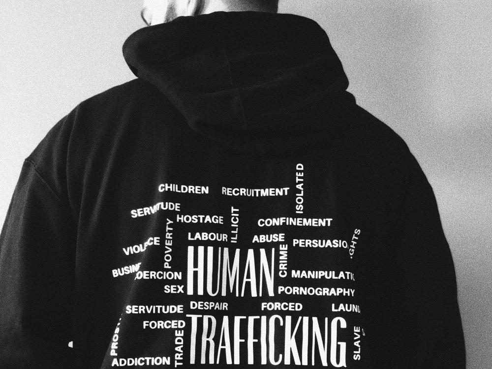 Man with back to camera and words on his hoodies related to human trafficking